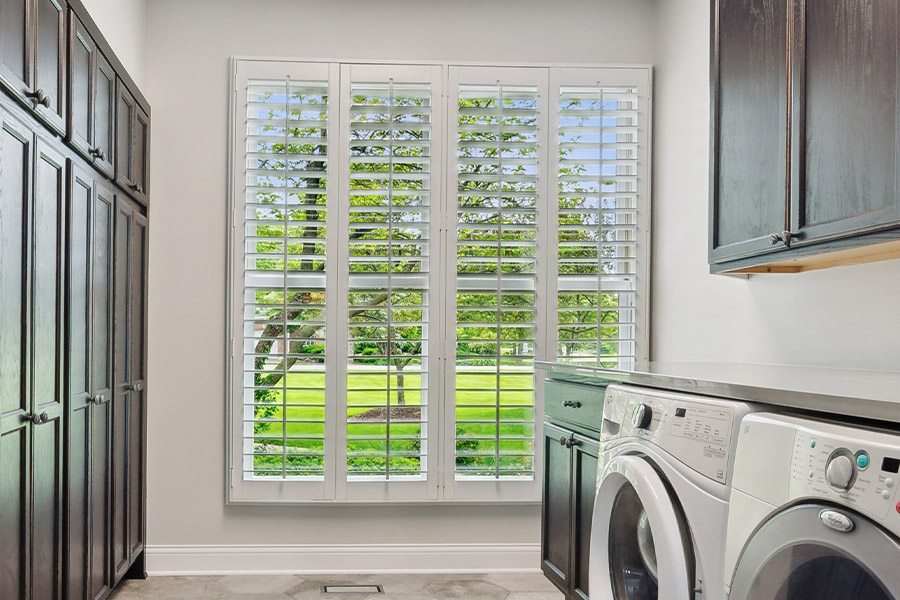 White Polywood shutters letting light through a laundry room window